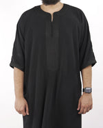 Close-up detail of the intricate traditional embroidery on the neckline and chest of a black half sleeve Moroccan thobe.