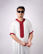 Man wearing a men's white short-sleeve thobe featuring detailed maroon embroidery on the neckline and cuffs, against a plain background.