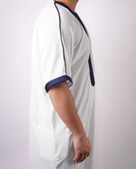 Side view close-up detailing the navy blue embroidered trim on the short sleeve cuff of a men's white thobe.