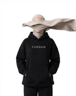 Woman in hijab wearing black Furqanwear Islamic hoodie with FURQAN wordmark on the chest
