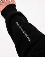 Sleeve of black Furqanwear Islamic hoodie printed with When the world turns away
