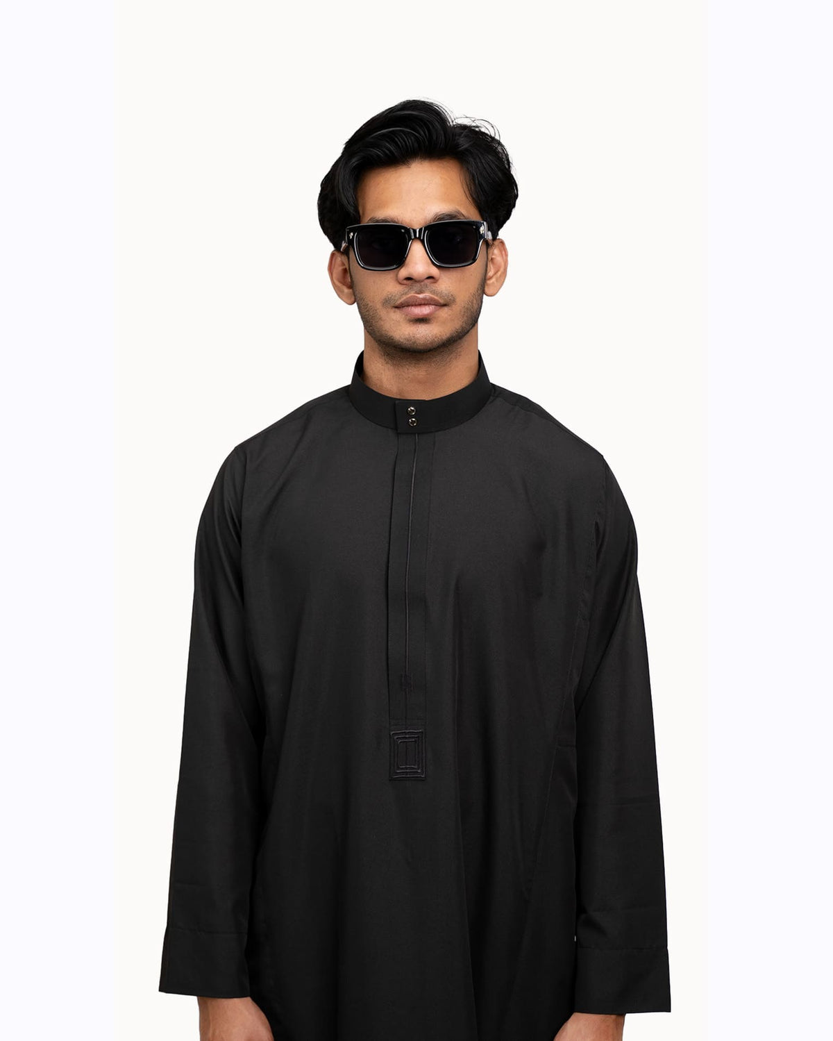 Man wearing a black Saudi thobe with a two-button stand collar and hidden placket
