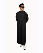 Side view of a black Saudi thobe showing the straight cut and buttoned cuff