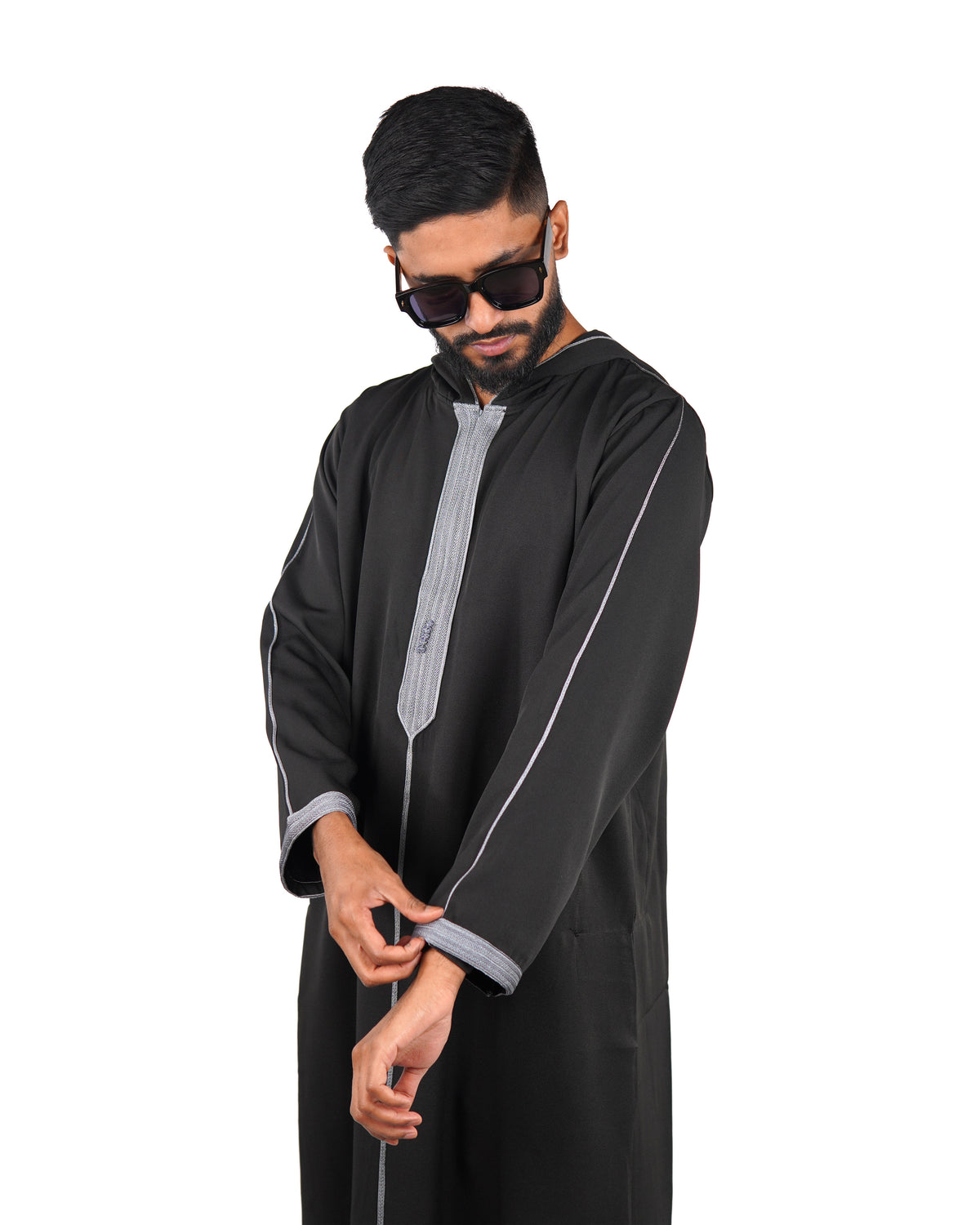 Model wearing a men's hooded black thobe with silver trim, showing upper body and cuff detail.