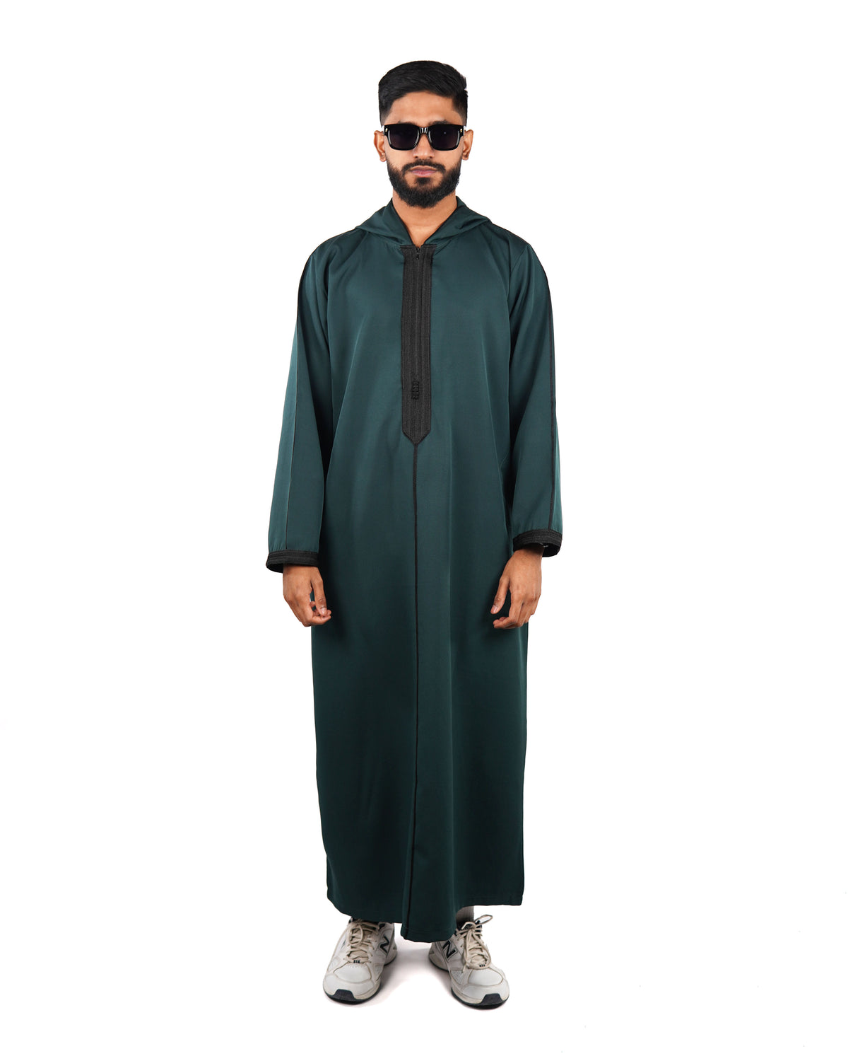 Full length front view of a man wearing a hooded green thobe (or djellaba) with black embroidered trim.