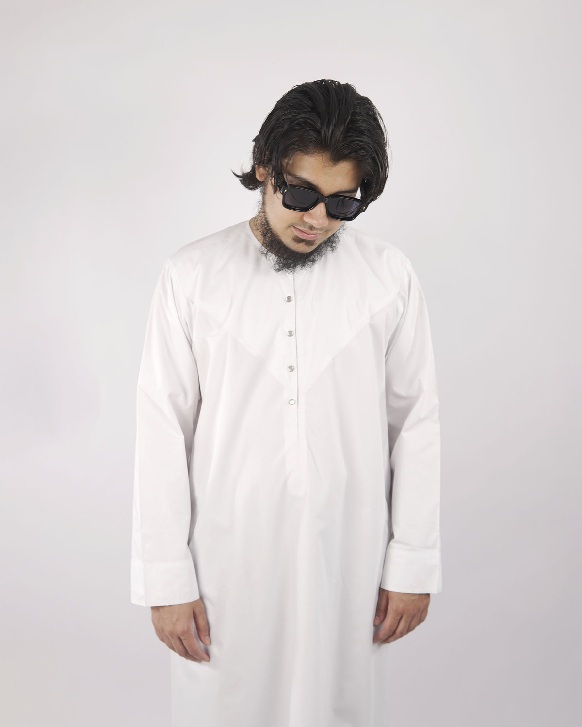 Close-up detail of a man in a white classic men's thobe jubba, showcasing the neckline and fabric, exemplifying traditional Islamic attire for men.