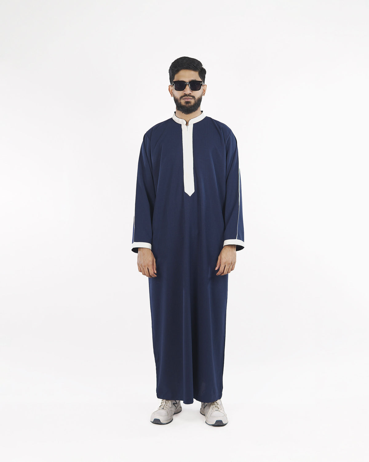 Model showcases the Royal Thobe in deep midnight navy with crisp white piping, a distinguished mens thobe jubba and islamic attire.